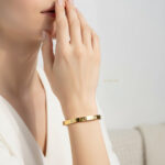 دستبند بنگل زنانه طلایی Catier مدل ELM8246 روی دست مدل زنانه