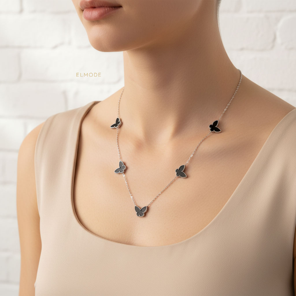 silver-butterfly-necklace-elm8302-model گردنبند زنانه طرح پروانه نقرهای مدل ELM8302 روی گردن مدل با نور نرم و پسزمینه طبیعی