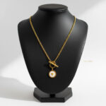 گردنبند زنانه ورساچه طلایی با قفل T مدل ELM8304 روی گردن مدل با نور استودیویی