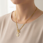 گردنبند زنانه ورساچه طلایی با قفل T مدل ELM8304 روی گردن مدل با نور استودیویی